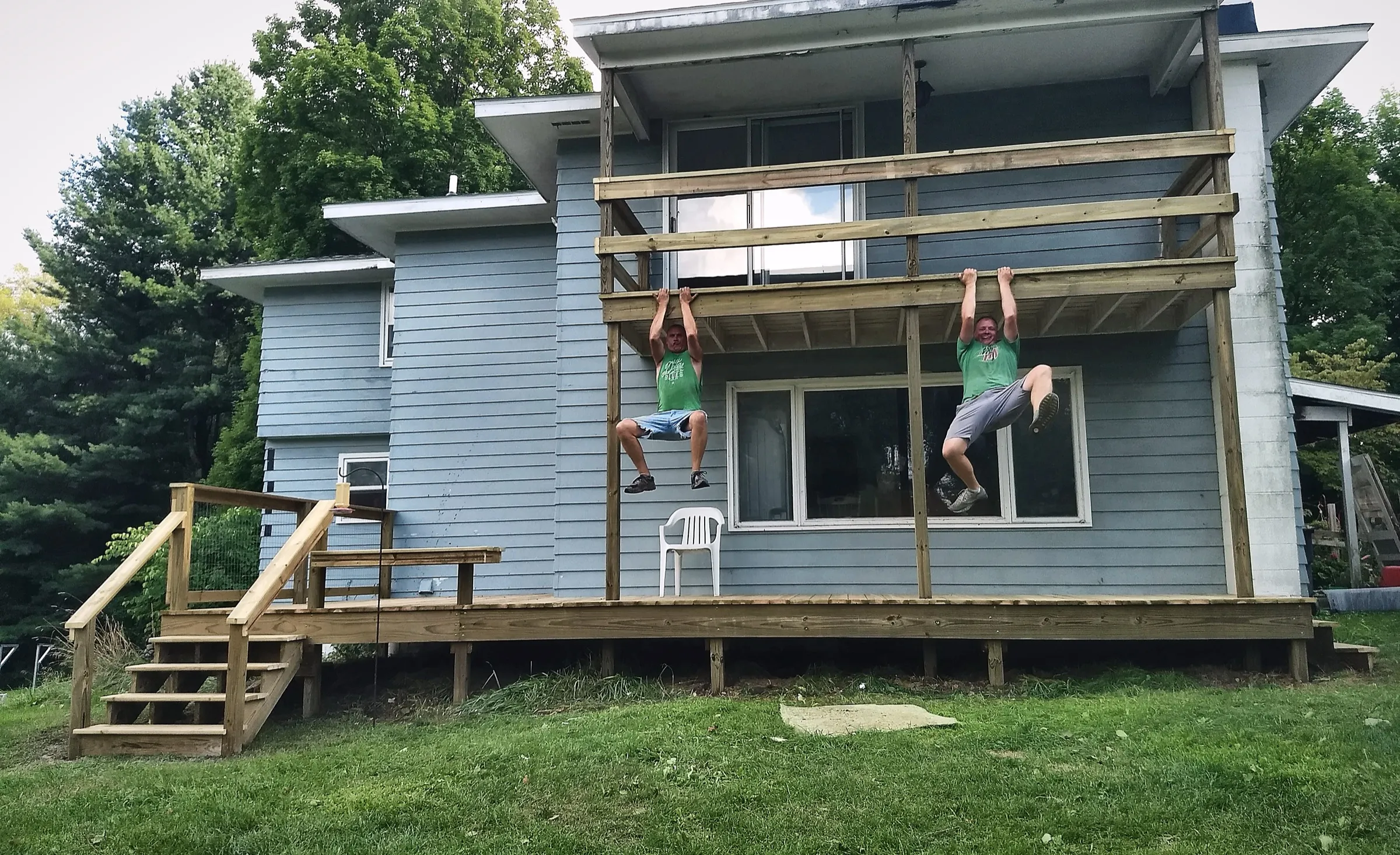 Todd and Randen doing pull-ups side by side on a freshly framed deck rim joist